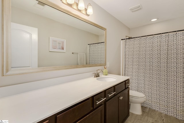 bathroom featuring vanity, hardwood / wood-style flooring, curtained shower, and toilet