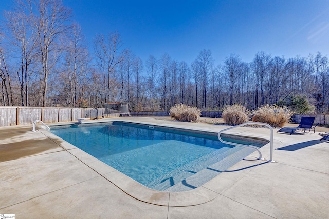 view of pool with a diving board and a patio area