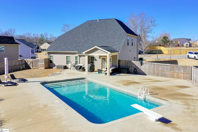 view of pool with a patio area and a diving board