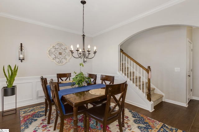 dining area featuring crown molding, dark wood-type flooring, and a chandelier