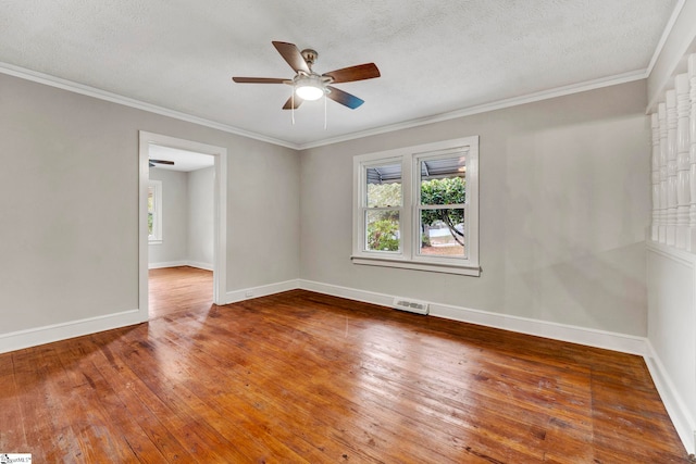 spare room featuring ceiling fan, ornamental molding, wood-type flooring, and a textured ceiling