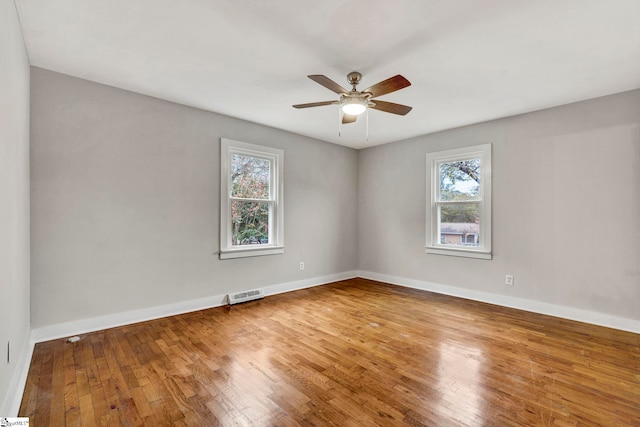 unfurnished room featuring wood-type flooring, ceiling fan, and plenty of natural light