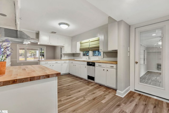 kitchen featuring butcher block countertops, light hardwood / wood-style floors, white cabinets, stainless steel dishwasher, and kitchen peninsula