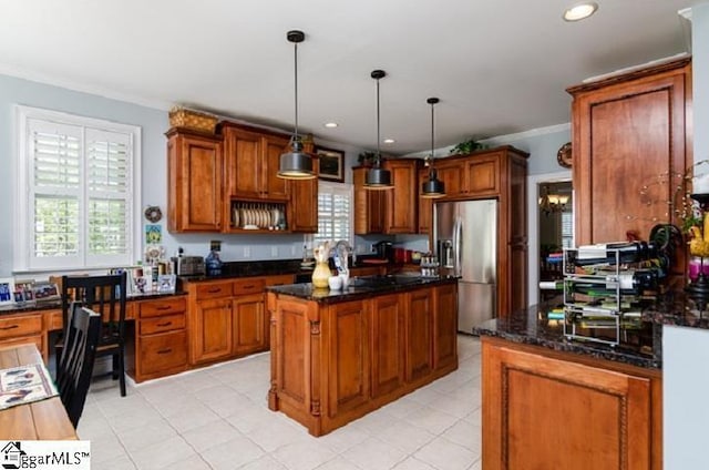 kitchen with pendant lighting, crown molding, a center island, stainless steel refrigerator with ice dispenser, and dark stone counters