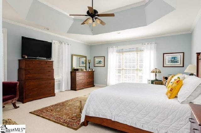 bedroom with ceiling fan, ornamental molding, a tray ceiling, and light carpet