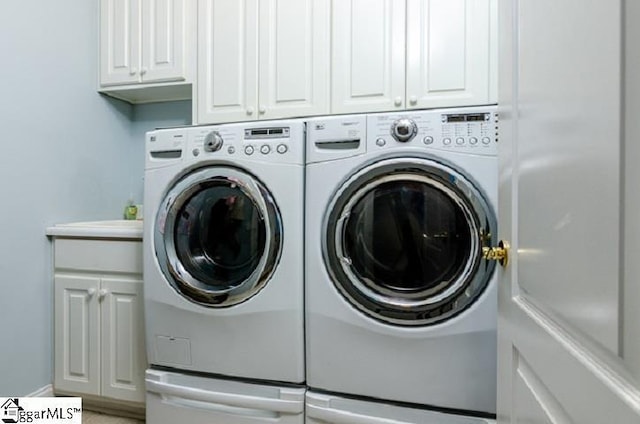 clothes washing area featuring cabinets and independent washer and dryer