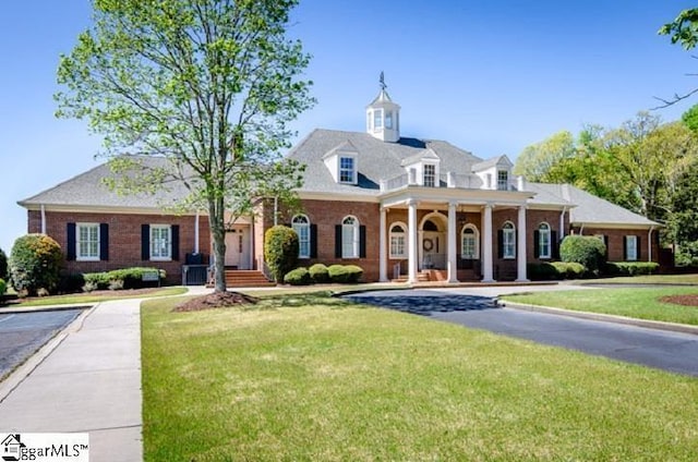 cape cod house featuring a front yard