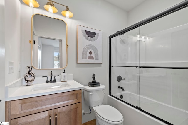 full bathroom featuring toilet, vanity, and shower / bath combination with glass door