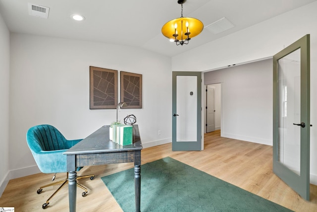 office space featuring french doors, lofted ceiling, wood-type flooring, and an inviting chandelier