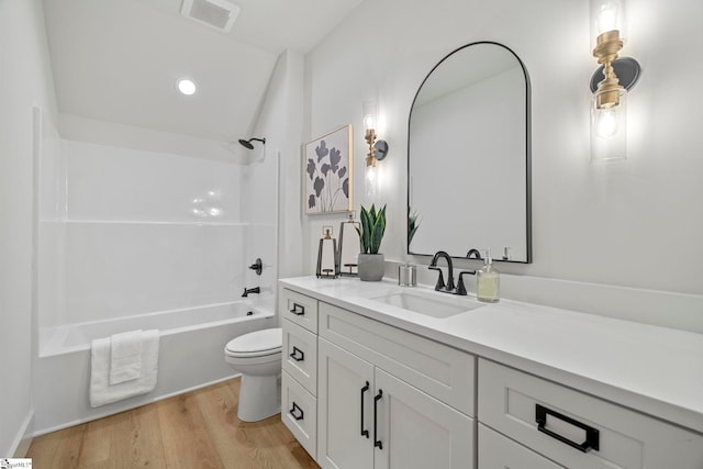 full bathroom featuring vanity, hardwood / wood-style flooring,  shower combination, and toilet