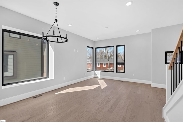 interior space featuring an inviting chandelier and light hardwood / wood-style flooring