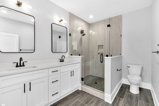 bathroom featuring vanity, an enclosed shower, and toilet