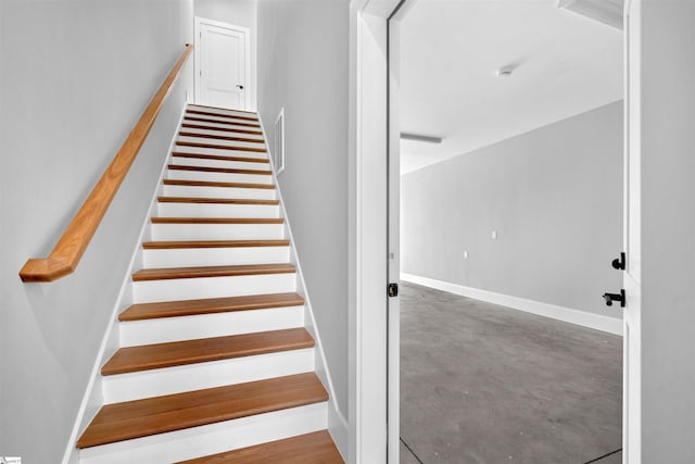 stairs featuring concrete flooring