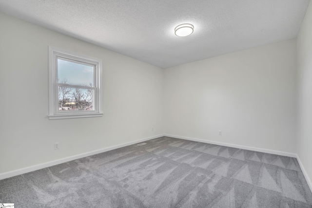 carpeted spare room featuring a textured ceiling