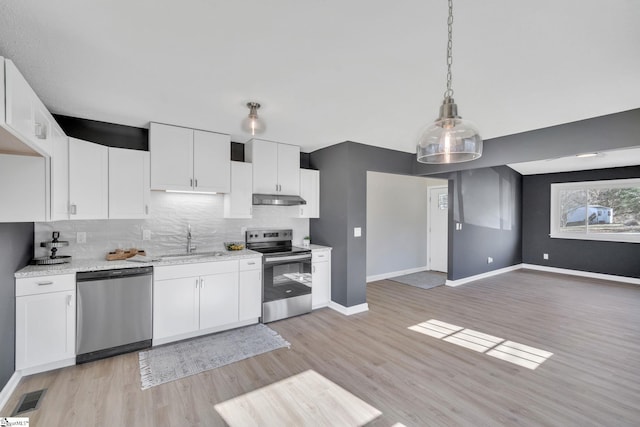 kitchen featuring sink, stainless steel appliances, tasteful backsplash, white cabinets, and decorative light fixtures