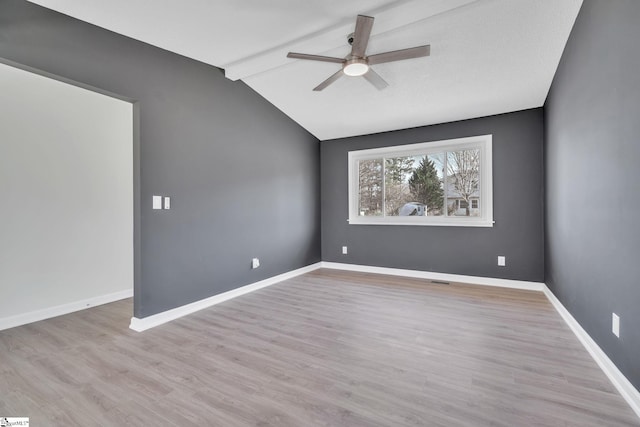 empty room featuring lofted ceiling with beams, ceiling fan, and light wood-type flooring