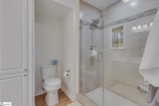 bathroom featuring an enclosed shower, wood-type flooring, and toilet