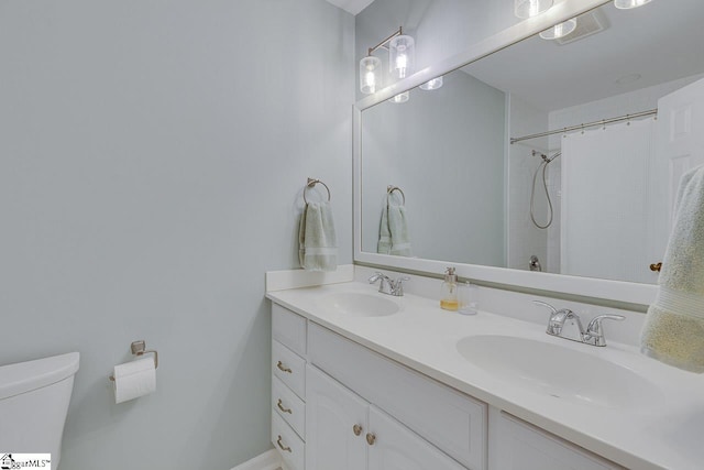 bathroom with vanity, curtained shower, and toilet