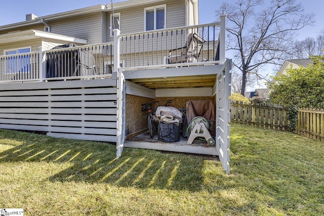 rear view of property with a deck and a lawn