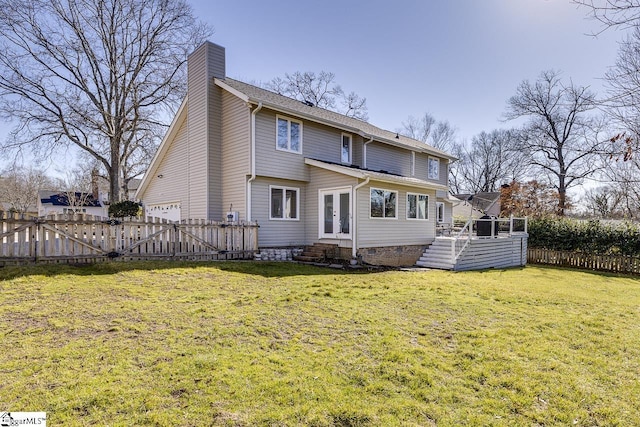 back of property featuring a wooden deck, a yard, and french doors