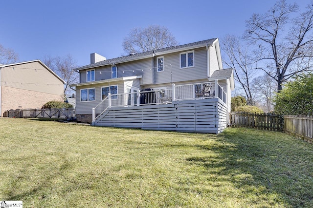 rear view of property featuring a lawn and a deck