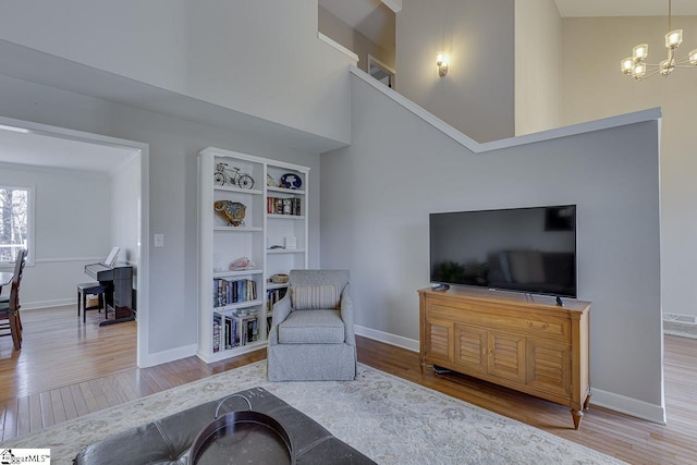 living room with an inviting chandelier, built in shelves, and wood-type flooring