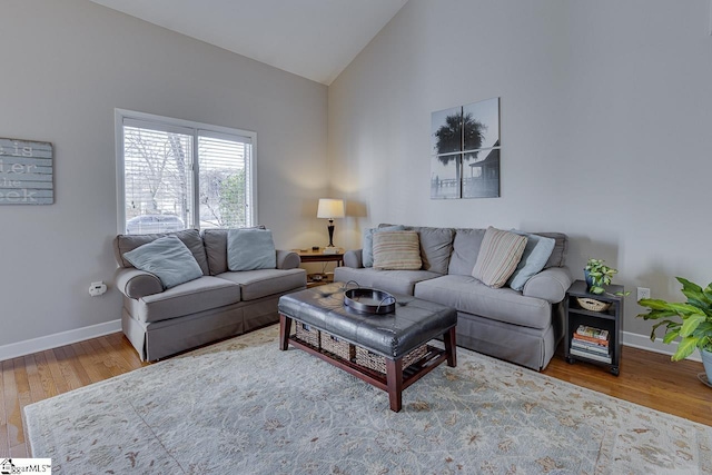 living room with hardwood / wood-style floors and high vaulted ceiling