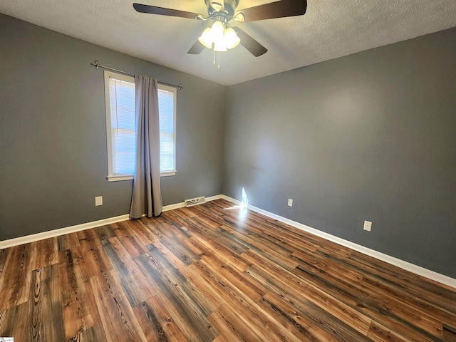 empty room featuring ceiling fan, a textured ceiling, and dark hardwood / wood-style flooring