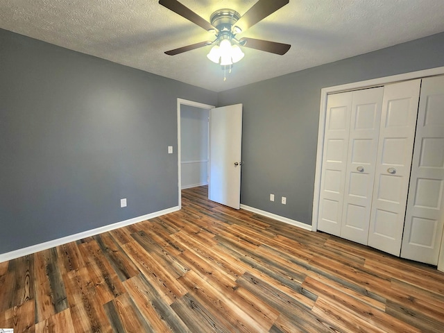 unfurnished bedroom with hardwood / wood-style floors, a textured ceiling, a closet, and ceiling fan