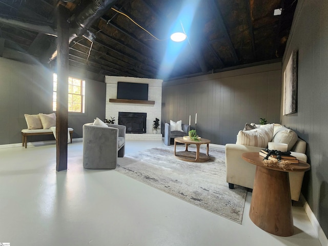 living room with wooden walls, a brick fireplace, and concrete floors