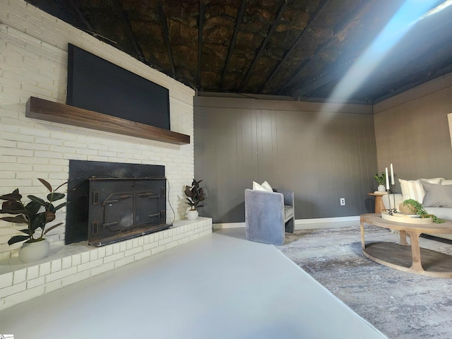 living room featuring a brick fireplace, concrete floors, and wood walls