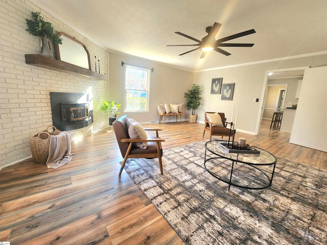 living room with wood-type flooring, ornamental molding, ceiling fan, and brick wall