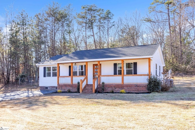 ranch-style home featuring covered porch and a front lawn