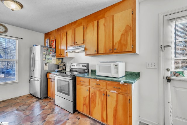 kitchen with a textured ceiling and appliances with stainless steel finishes