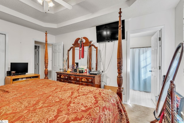 carpeted bedroom with ceiling fan, a raised ceiling, and a textured ceiling