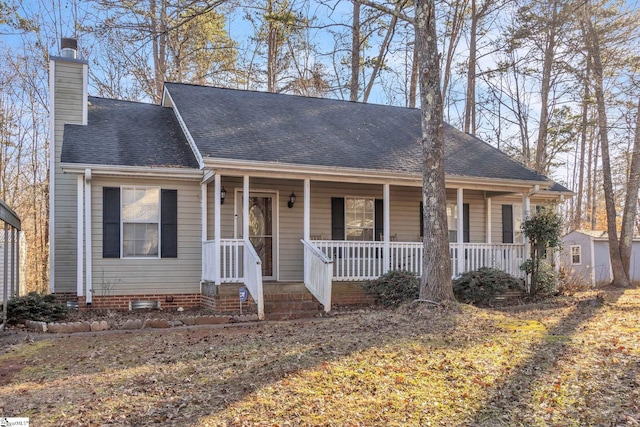 view of front of house with a storage unit and covered porch