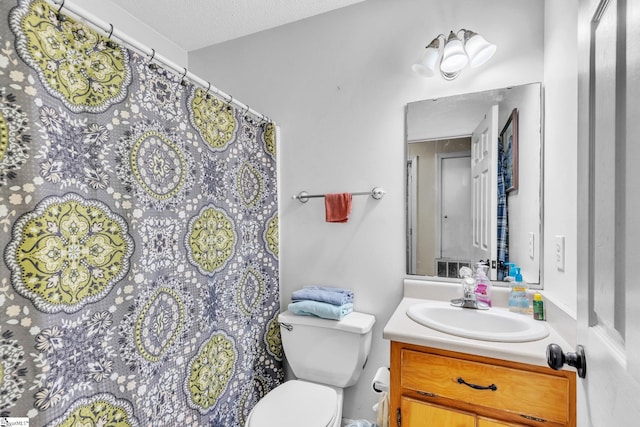 bathroom featuring vanity, a textured ceiling, and toilet