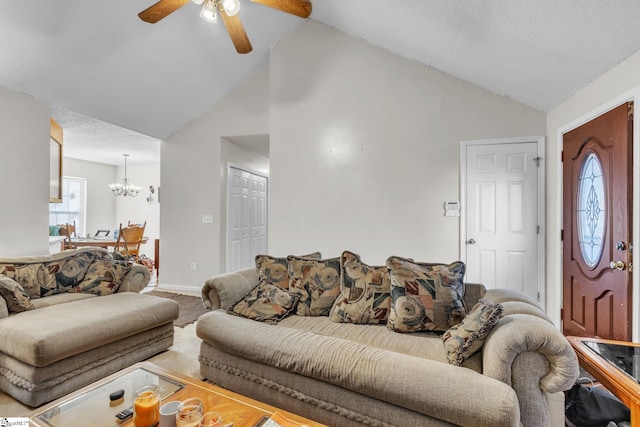 living room featuring lofted ceiling, ceiling fan with notable chandelier, and a textured ceiling