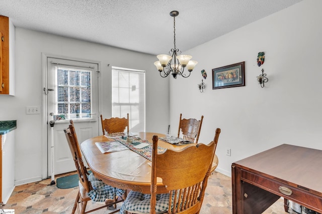 dining space featuring an inviting chandelier and a textured ceiling