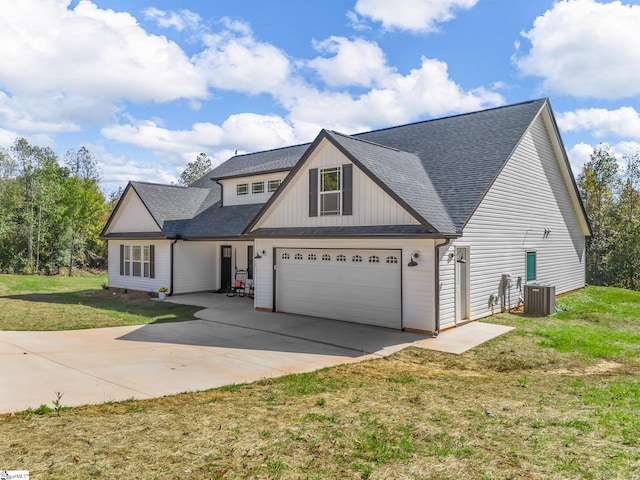 view of front of home with central AC unit, a garage, and a front lawn