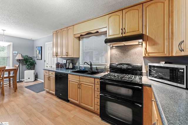 kitchen featuring sink, hanging light fixtures, black appliances, a textured ceiling, and light hardwood / wood-style flooring