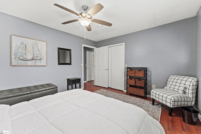 bedroom featuring dark wood-type flooring, ceiling fan, and a closet