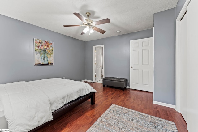 bedroom featuring ceiling fan, dark hardwood / wood-style flooring, and a textured ceiling