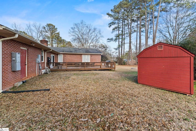 view of yard featuring a wooden deck and a storage unit