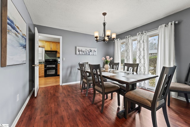 dining area with dark hardwood / wood-style floors, a textured ceiling, and a chandelier