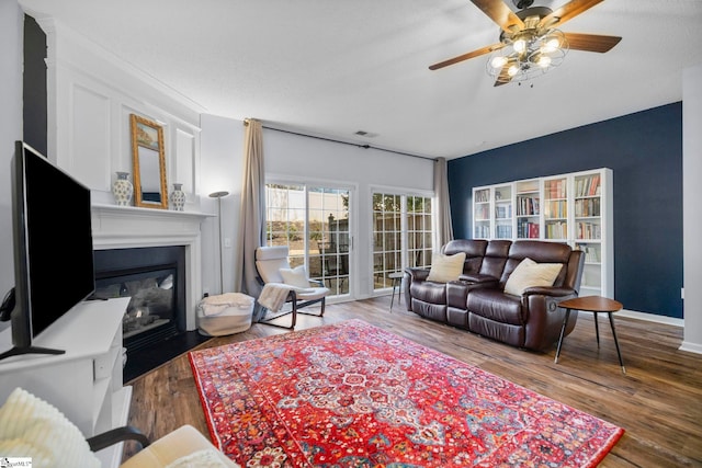 living room with hardwood / wood-style floors, a textured ceiling, and ceiling fan