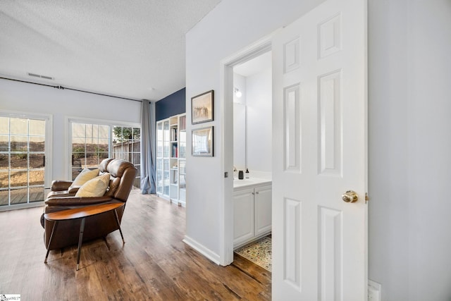 living area featuring hardwood / wood-style flooring and a textured ceiling