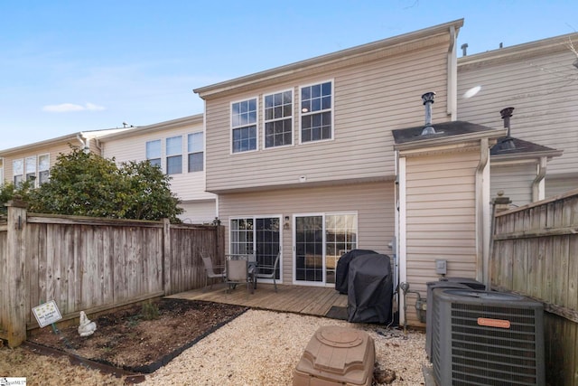 back of house featuring central AC unit and a deck