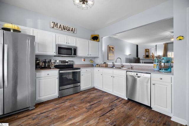 kitchen featuring sink, white cabinets, dark hardwood / wood-style flooring, kitchen peninsula, and stainless steel appliances