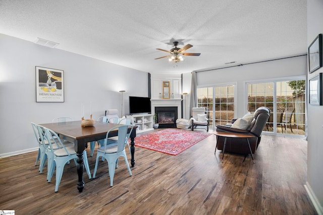 dining area featuring wood-type flooring, ceiling fan, and a textured ceiling